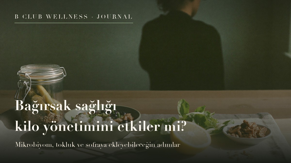 Ahşap tezgâhta sade yoğurtlu kâse, ev turşusu kavanozu, ceviz, taze yeşillik ve limon; sakin, doğal ışıklı bir mutfak sahnesi.